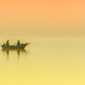 Fritidsfiskere i båd med solnedgang
